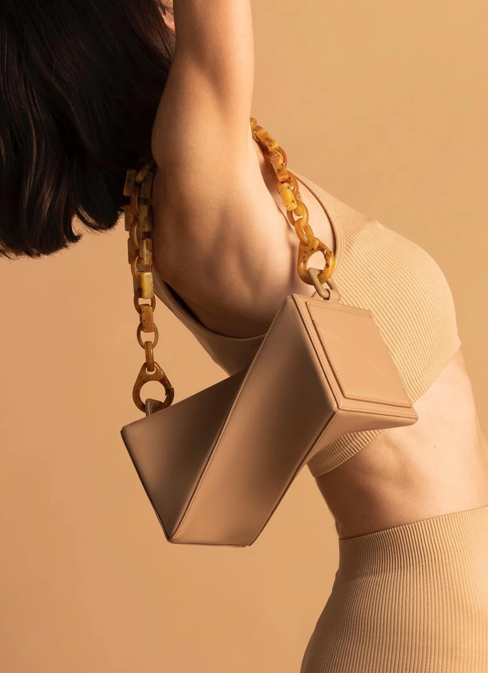 Alt Text: woman-carrying-modern-inspired-geometric-handbag-with-chain-strap-premium-fashion-ecommerce-banner