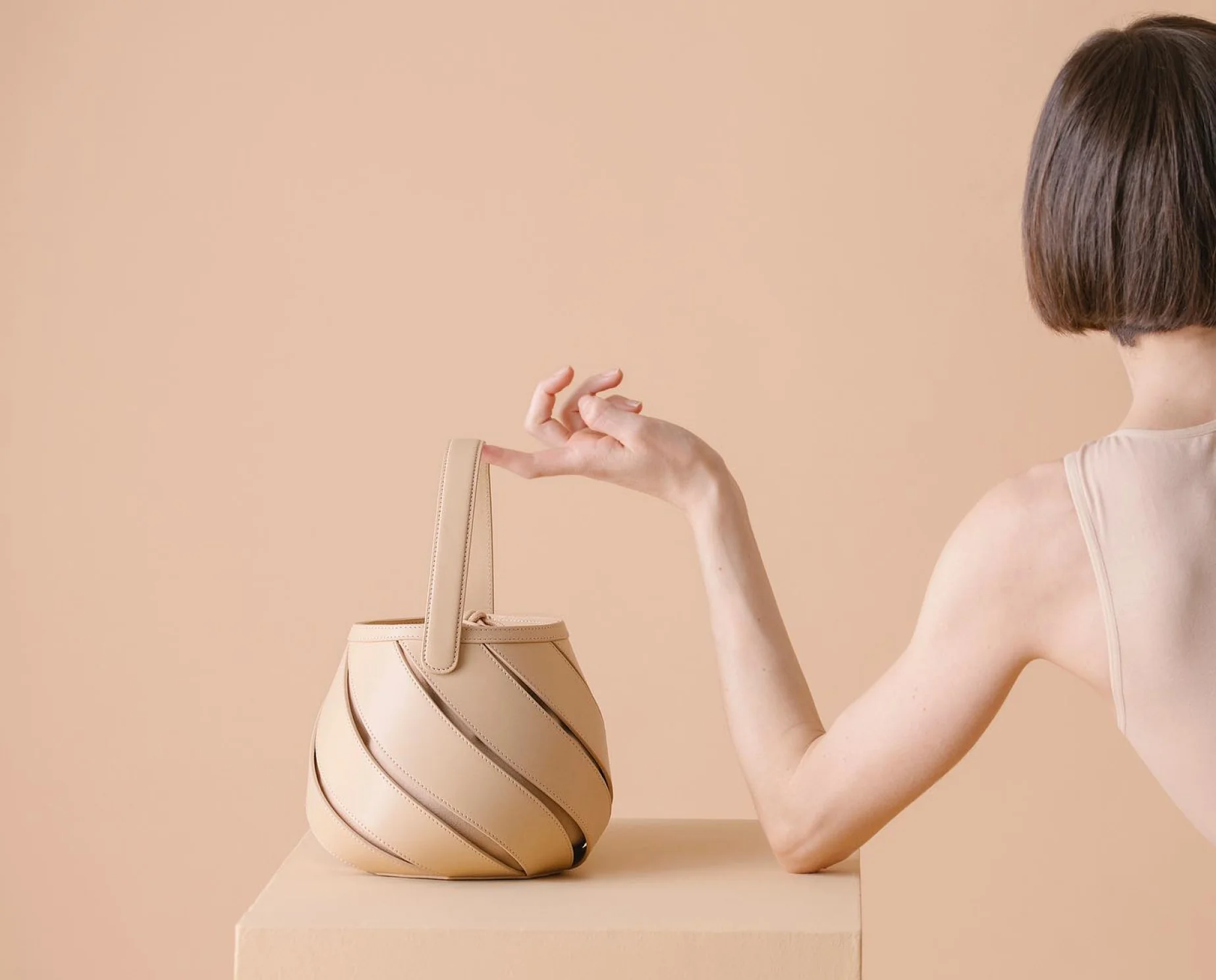 woman-holding-elegant-inspired-handbag-beige-background-premium-fashion