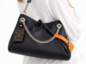 Louis-Vuitton-Black-Leather-Shoulder-Bag-with-Silver-Chain-Strap-and-Monogram-Tag-on-Women-Shoulder-White-Background-Hero-Image